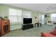 Bright, retro-style living room with large windows, curtains, a ceiling fan, and cozy seating at 304 Roma Rd, Venice, FL 34285