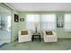 Cozy living room with green walls, white furniture, and natural light from two windows at 304 Roma Rd, Venice, FL 34285