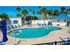 Community pool with lounge chairs, palm trees, and a clear blue sky at 304 Roma Rd, Venice, FL 34285
