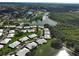 Aerial view highlighting a residential neighborhood nestled between a lake and green spaces, offering a tranquil living environment at 3141 Heron Shores Dr, Venice, FL 34293