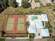 Aerial view featuring the pool, tennis courts, and parking lot of the residential community at 3141 Heron Shores Dr, Venice, FL 34293