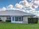 Backyard featuring a screened-in lanai, lush landscaping, and villa exterior at 3141 Heron Shores Dr, Venice, FL 34293