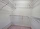 Walk-in closet featuring white metal shelving units and neutral carpeting, providing ample storage space at 3141 Heron Shores Dr, Venice, FL 34293