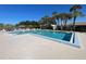 Inviting community pool surrounded by lush palm trees and comfortable lounging areas offers relaxation and recreation at 3141 Heron Shores Dr, Venice, FL 34293