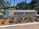 The Heron Shores community sign features a blue heron and is surrounded by lush landscaping and mulch at 3141 Heron Shores Dr, Venice, FL 34293