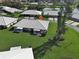 Aerial view showing a home with a neutral tile roof, well-kept lawn, and a private screened-in patio at 3141 Heron Shores Dr, Venice, FL 34293