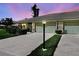 Villa featuring an attached garage, lamp post, and manicured lawn at dusk at 3141 Heron Shores Dr, Venice, FL 34293