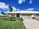 Charming villa with an attached garage, an American flag, and verdant lawn at 3141 Heron Shores Dr, Venice, FL 34293