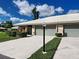 Attractive home exterior with two garage doors, well-maintained landscaping, and a paved driveway at 3141 Heron Shores Dr, Venice, FL 34293