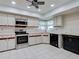 Traditional kitchen with stainless steel appliances, white cabinets, and tile flooring at 3141 Heron Shores Dr, Venice, FL 34293