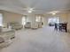 Expansive living room with plush carpeting, neutral tones, ceiling fan and a dining area, perfect for relaxing and entertaining at 3141 Heron Shores Dr, Venice, FL 34293