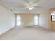 Spacious living room with carpet, ceiling fan, and bright windows with sheer curtains at 3141 Heron Shores Dr, Venice, FL 34293