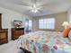 Cozy bedroom with a colorful seashell-themed quilt, dresser, and sliding doors to the lanai for a relaxing retreat at 3141 Heron Shores Dr, Venice, FL 34293