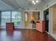 Bright sunroom with wood-look floors offers a glimpse into the adjacent bedroom at 3141 Heron Shores Dr, Venice, FL 34293