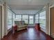 Inviting sunroom filled with natural light boasts wood-look floors and comfortable seating at 3141 Heron Shores Dr, Venice, FL 34293