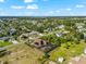 An aerial view of a home with a pool and solar panels in a lush, green neighborhood under a blue sky with fluffy clouds at 329 Myrtle Ave, Nokomis, FL 34275