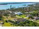 A waterfront home with a well-maintained lawn and lush landscaping under a bright blue sky with scattered clouds at 329 Myrtle Ave, Nokomis, FL 34275