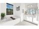 A bright bathroom with tub, dual sinks and natural light from a window overlooking greenery at 329 Myrtle Ave, Nokomis, FL 34275