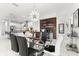 Open dining area with modern chandelier and glass table connecting to a sleek kitchen at 329 Myrtle Ave, Nokomis, FL 34275