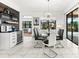 Open dining area with modern glass table, connecting to coffee bar and outdoor view at 329 Myrtle Ave, Nokomis, FL 34275