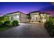 Charming, single-story home featuring manicured landscaping and a brick paved driveway at 329 Myrtle Ave, Nokomis, FL 34275