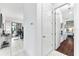 Hallway with white marble flooring leading to a bedroom with hardwood floors at 329 Myrtle Ave, Nokomis, FL 34275