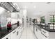 Modern kitchen featuring stainless steel backsplash, black countertops, and white cabinetry at 329 Myrtle Ave, Nokomis, FL 34275