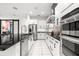 Sleek kitchen boasting stainless steel appliances, white cabinets, and a spacious island with marble floors at 329 Myrtle Ave, Nokomis, FL 34275