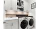 Functional laundry room with upper cabinets and side-by-side washer and dryer units at 329 Myrtle Ave, Nokomis, FL 34275