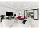 Well-lit living room featuring a contemporary design, comfortable seating, and a sliding barn door to the office at 329 Myrtle Ave, Nokomis, FL 34275