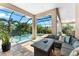 Charming outdoor patio with a comfortable seating area and tranquil views of the pool and backyard at 329 Myrtle Ave, Nokomis, FL 34275
