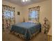 Bedroom featuring a blue comforter with floral curtains and two bedside lamps at 3311 Papaya Rd, Venice, FL 34293