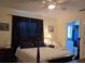 Bedroom featuring a wooden four poster bed with dark blue curtains and an attached bathroom at 3311 Papaya Rd, Venice, FL 34293