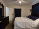Bedroom featuring a dark wooden dresser with a white comforter and dark blue curtains at 3311 Papaya Rd, Venice, FL 34293