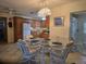 Bright dining area features a glass table with seating for four and adjacent access to a modern kitchen at 3311 Papaya Rd, Venice, FL 34293