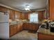 Kitchen featuring granite countertops, wood cabinets, tile flooring, and stainless steel appliances at 3311 Papaya Rd, Venice, FL 34293