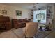 Comfortable living room with a brown sofa, ceiling fan, and built-in shelving with decorative stained glass window at 3311 Papaya Rd, Venice, FL 34293