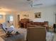 Open living room includes a comfortable sofa, a functional rolltop desk, and a ceiling fan at 3311 Papaya Rd, Venice, FL 34293