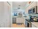 Bright kitchen with stainless steel appliances, white cabinetry, and a pass-through to another room at 3382 Mermoor Dr # 3201, Palm Harbor, FL 34685