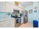 Well-maintained kitchen equipped with stainless steel appliances, white cabinets, and bright lighting at 3382 Mermoor Dr # 3201, Palm Harbor, FL 34685