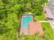 An aerial view shows the community pool featuring a screened enclosure and ample lounging space at 3382 Mermoor Dr # 3201, Palm Harbor, FL 34685