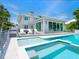 The backyard oasis boasts a pool, hot tub, lounge area, and expansive windows with water views at 3516 Casey Key Rd, Nokomis, FL 34275