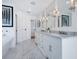 Bright bathroom featuring a marble floor, double vanity, and modern fixtures at 3516 Casey Key Rd, Nokomis, FL 34275