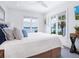 Bright bedroom featuring lake views from the windows, white walls, and a large plush bed with decorative pillows at 3516 Casey Key Rd, Nokomis, FL 34275