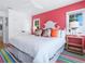 Bright bedroom featuring a ceiling fan, pink accent wall, with a large plush bed and tropical-themed pillows at 3516 Casey Key Rd, Nokomis, FL 34275
