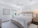 Bright bedroom featuring a ceiling fan, light gray walls, light-colored carpet, and a large textured bed frame at 3516 Casey Key Rd, Nokomis, FL 34275