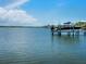 Scenic view of a private boat dock with a motorboat, capturing the essence of waterfront living and recreational opportunities at 3516 Casey Key Rd, Nokomis, FL 34275
