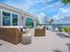 This cozy outdoor deck features wicker furniture, a stone side table, and stunning views of the waterfront at 3516 Casey Key Rd, Nokomis, FL 34275