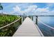 A private boat dock providing direct access to the water, surrounded by lush greenery and offering serene waterfront views at 3516 Casey Key Rd, Nokomis, FL 34275