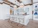 Bright kitchen features a center island with seating, pendant lights, white cabinets, and wood beam accents at 3516 Casey Key Rd, Nokomis, FL 34275